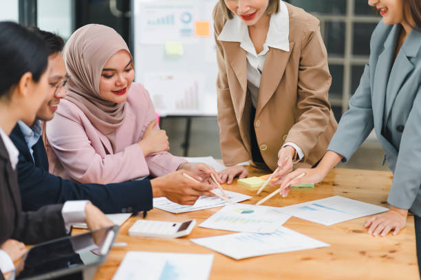 istock Diverse business team collaborates and analyzes reports during meeting, highlighting teamwork and strategic planning in modern office. 2158255023
