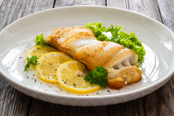 istock Fried halibut steak and fresh vegetables on wooden table 2158256763