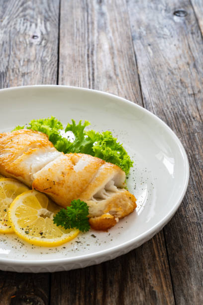 istock Fried halibut steak and fresh vegetables on wooden table 2158256800