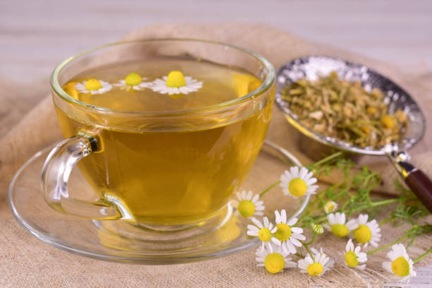 istock Herbal chamomile tea with honey, and medicinal chamomile flowers. Close-up. 2158257671
