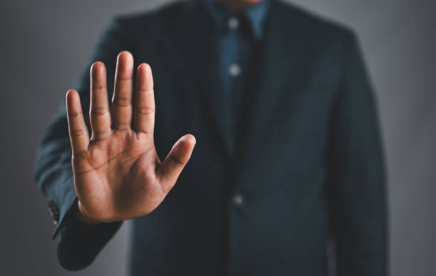 istock Male hand showing stop gesture, concept of stop violence. Warning, prohibition, denial. On dark background. 2158259727