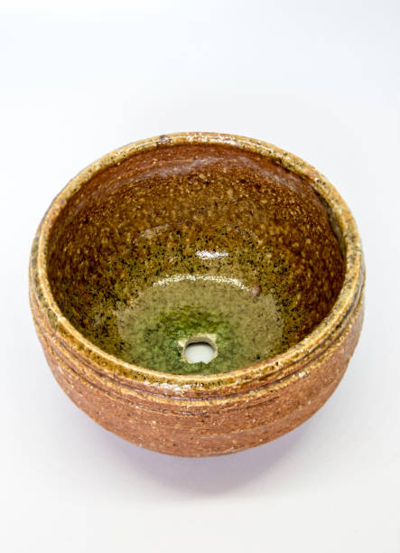 The ceramic cup has been adapted for planting small pot plants