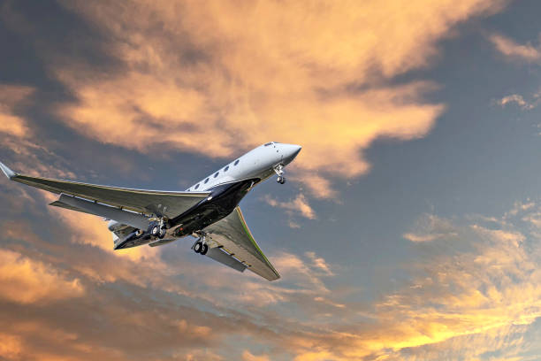 istock Private business plane flying under an orange sunset sky 2158266054