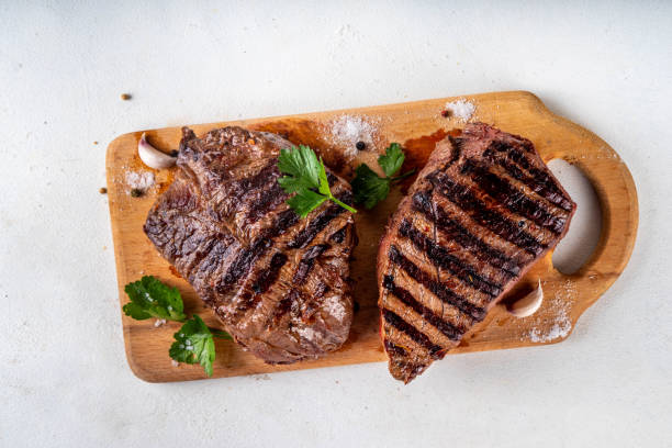 istock Grilled beef steak on wooden cutting board 2158266279