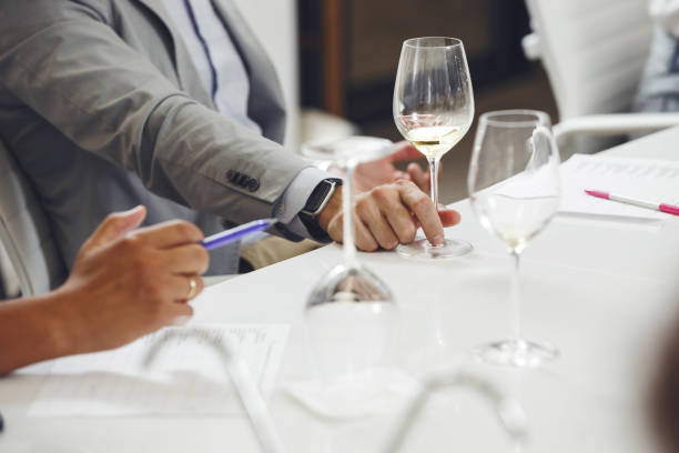 istock Wine experts association, sommelier school, professional development. Sommelier wearing in casucal jacket tasting white wine from glass, analysing its taste, color, smell and acidity level. 2158268013