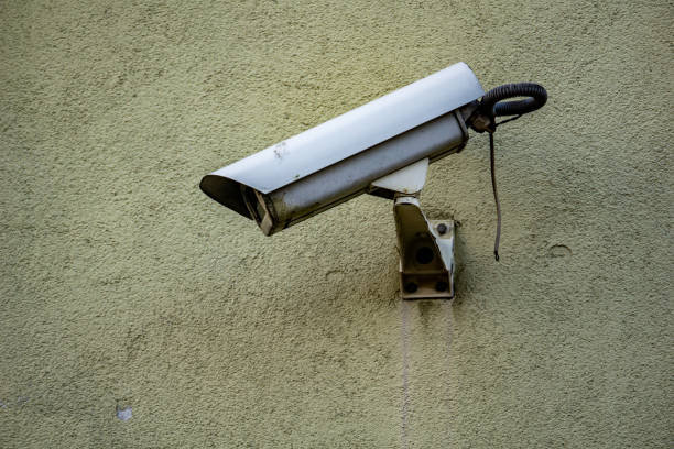 istock Security Camera Mounted on a Green Wall monitoring state surveillance security concept 2158268575
