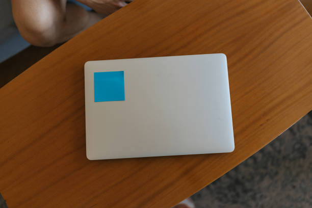 istock Laptop with blue sticker on wooden table 2158268945