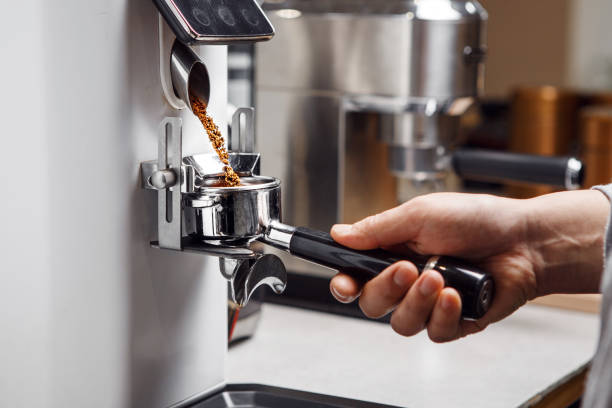 Pouring Portafilter With Freshly Ground Coffee for Espresso in Coffee Shop, Close up
