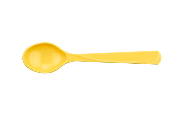 Yellow plastic spoon isolated on white isolated background with clipping path.
