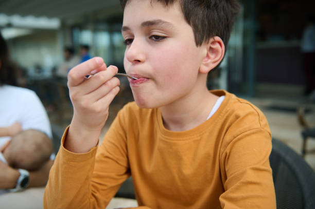 Portrait of a happy Asian boy enjoying chocolate cookies in a cafe