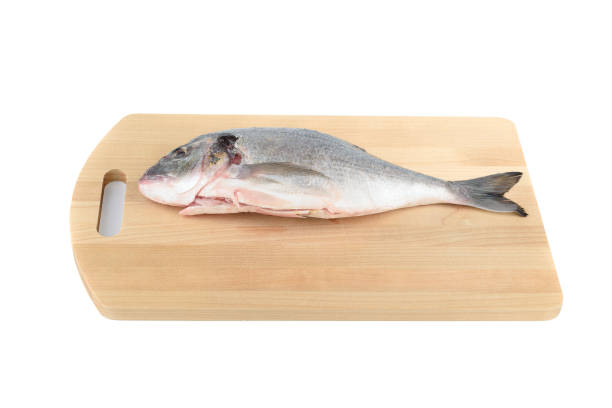 istock Cleaned and poached dorada fish on a wooden cutting board. 2158270848