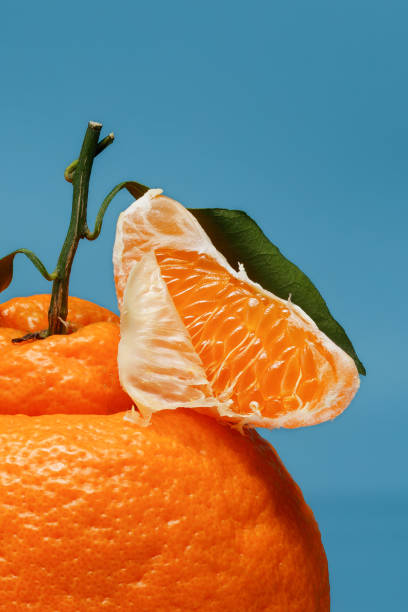 istock Slice of tangerine on a blue background. 2158271183