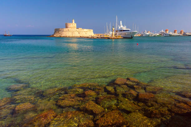 St Nicholas Fortress in Rhodes, Greece with yachts and clear turquoise water