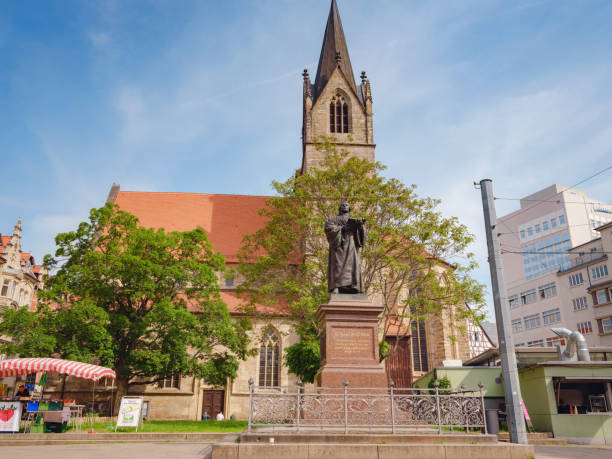 Erfurt, Germany - May 21, 2023: Monument to Martin Luther on Anger Square in Erfurt, Thuringia with Evangelical Church St. Gregor on backdrop