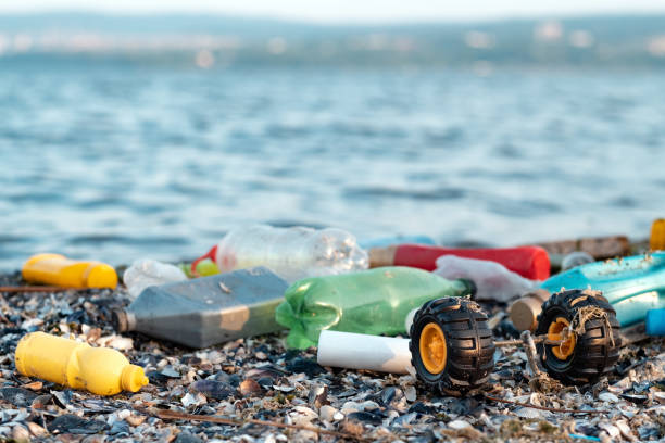istock Ecological problem. Moving waves. Spilled garbage on beach of big city. Empty used dirty plastic bottles, children's plastic toys. Dirty sea, sandy coast the Black Sea. Environmental pollution 2158279688