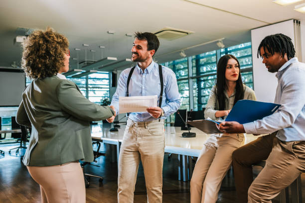 istock New colleagues meet for the first time. Shaking hands on first day of work. Multiracial group of colleagues. 2158280536