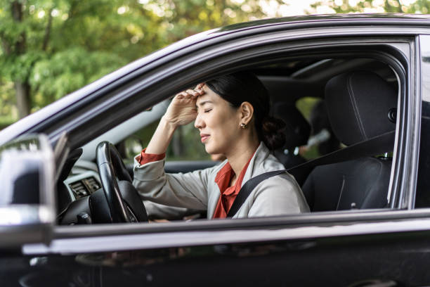 istock Tired driver in her car, view from outside. Stuck in traffic jam 2158282835