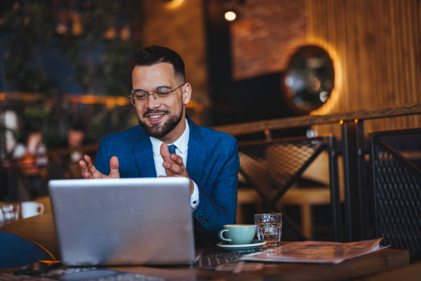 istock Smiling Businessman with Laptop at Coffee Shop 2158285012