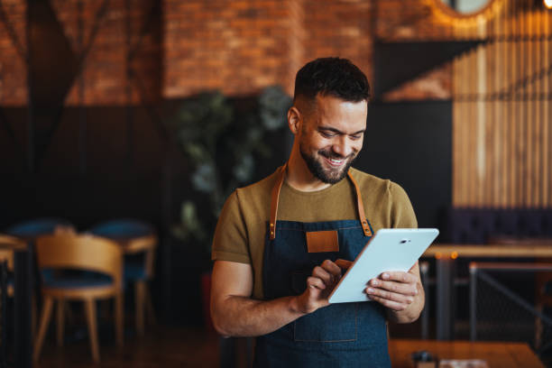 istock Smiling Caucasian Waiter Using Tablet in Restaurant 2158285074
