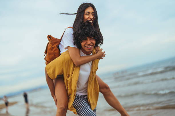 istock Joyful Hispanic Couple Enjoying Piggyback Ride on the Beach 2158285293
