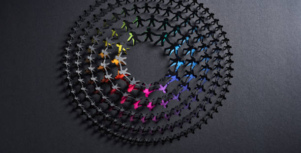 istock Circular Chain of Multicolored Paper Cutout Figures on a Dark Textured Background 2158286020