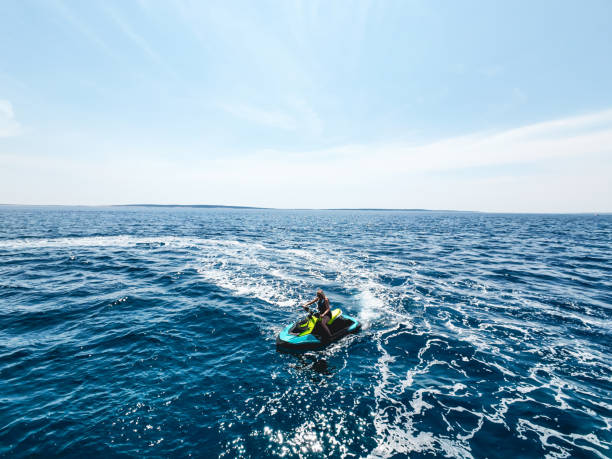 istock Female jet skier racing through waves on rough waters 2158286491