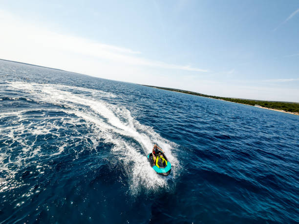 istock Woman jet skier racing through waves on rough waters 2158286496