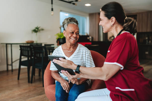 istock Home care healthcare professional using digital tablet 2158288250