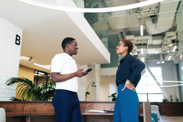 istock Two black colleagues talking at the modern office 2158291270