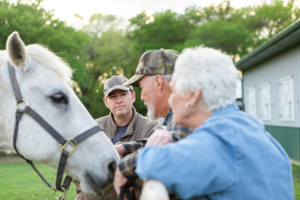 istock Son listens to advice from senior dad about horse 2158291548