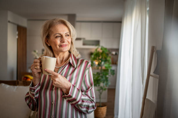 istock Elderly retired woman drinking coffee and relaxing at home 2158292678