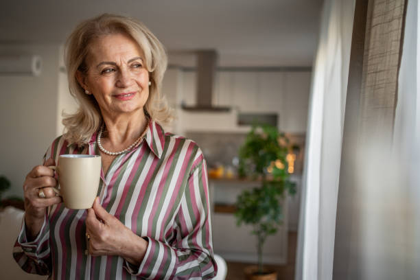 istock Elderly retired woman drinking coffee and relaxing at home 2158292696