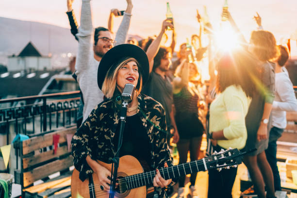 istock Friends enjoying a guitar performance on the rooftop 2158298575