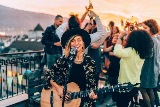 istock Friends enjoying a guitar performance on the rooftop 2158298629