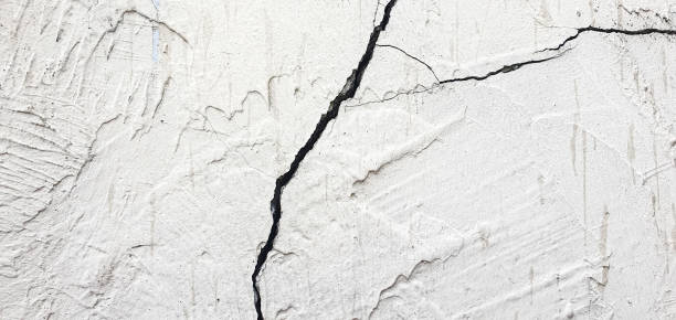 istock Cracked plaster. Damaged plastered, concrete wall in chips, cracks 2158300852