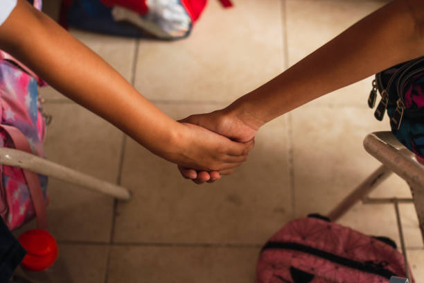 Latina students holding hands, friendship in the clasroom