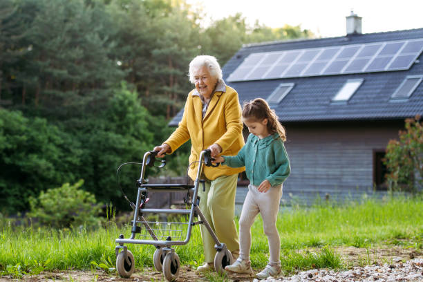 Granddaughter spending time with elderly grandma, companionship. Senior lady with walker spending time in nature. Granddaughter spending time with elderly grandma, companionship. Senior lady with walker spending time in nature. Weekend in cottage. special needs child pictures stock pictures, royalty-free photos & images