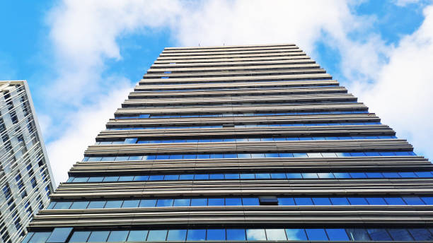 istock Modern office building reflecting blue sky and clouds on a sunny day 2158313169