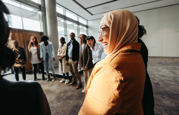 Diverse team bonding activity with Muslim woman in circle during workshop