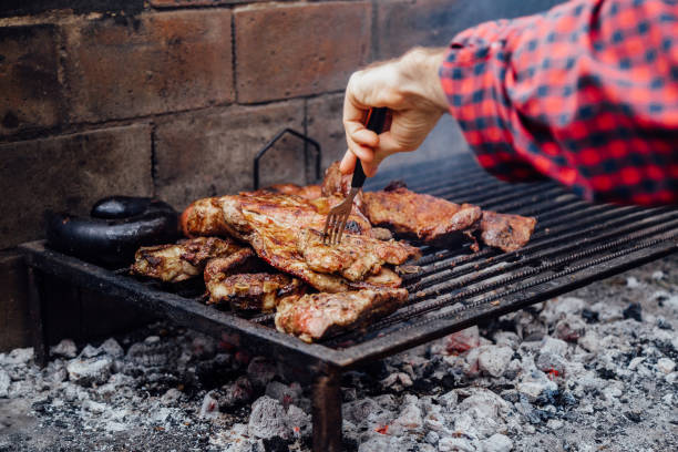 istock Young man doing a bbq. Traditional Asado of Argentina. 2158315558