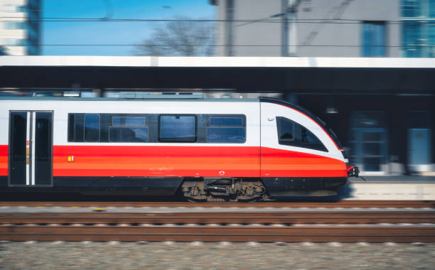 istock High-speed orange passenger train moving at railway station platform at sunset. Train station. Modern railway transportation concept with blurred motion effect. Railroad. Commercial transport 2158316491
