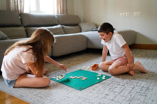 istock Two children playing dominoes on a green mat 2158317550