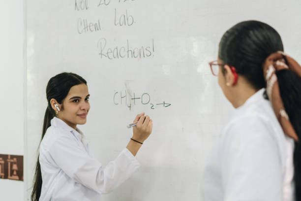 istock Student solving a chemistry exercise with the help of the teacher in the laboratory 2158322922