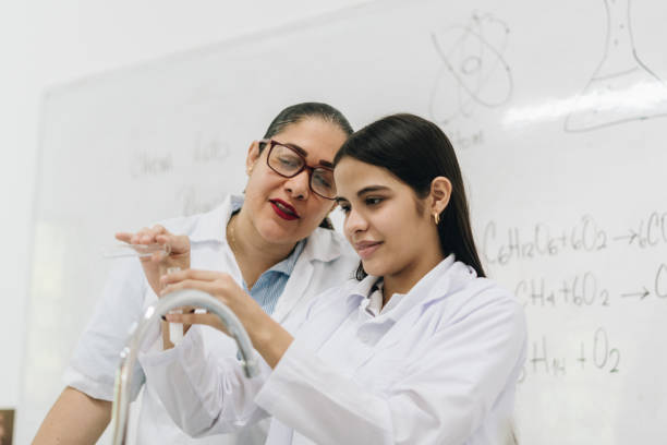 istock Teacher helping student with scientific experiment in school laboratory 2158323006