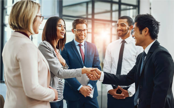 istock Group, business people and shaking hands for welcome, introduction or meeting in office. Handshake, smile and team with deal for collaboration, agreement or thank you for b2b partnership opportunity 2158323033