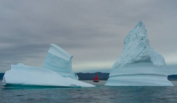 istock two icebergs with one red sailboat 2158323456
