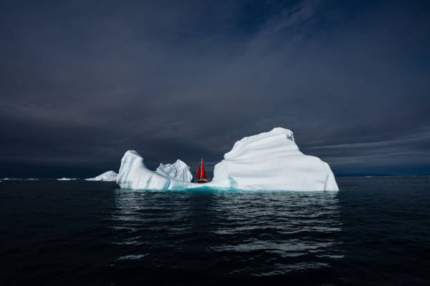istock Moody Iceberg with red sail boat 2158323458