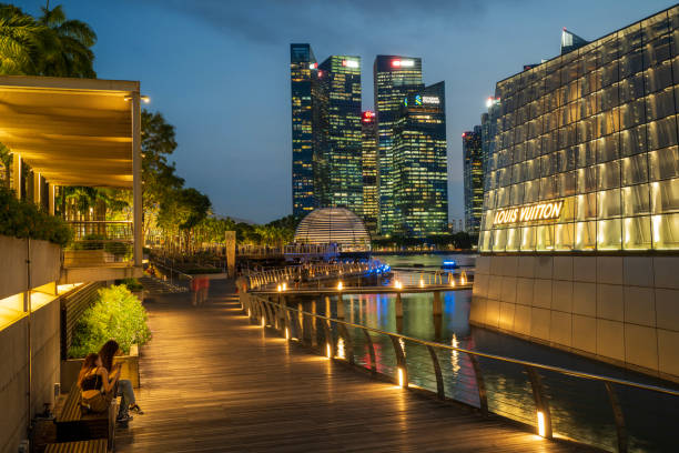 Singapore, Singapore - April 2, 2024. Tourists at Marina Bay Waterfront Promenade at night, Singapore