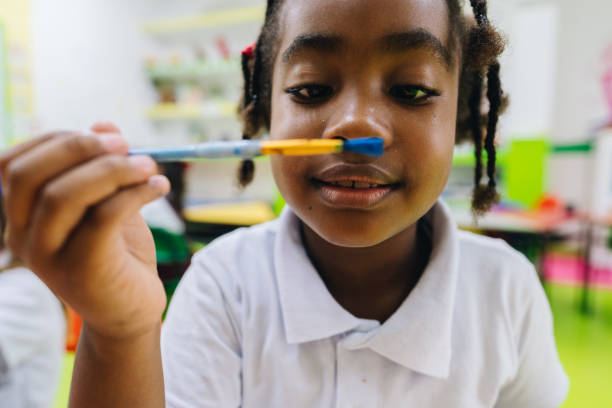 istock Girl holding paintbrush at school 2158327239