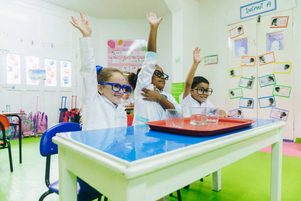 Children asking questions during chemistry class at school laboratory